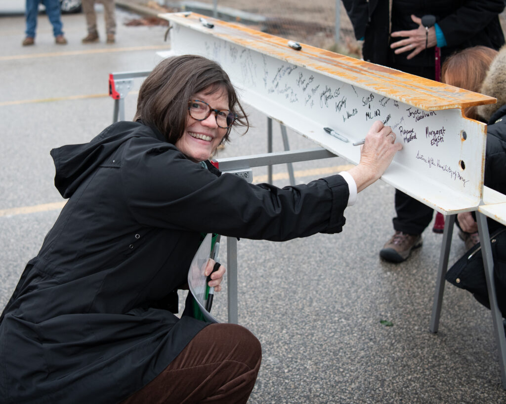 Sister Susan signing the beam at the Topping Out Ceremony
