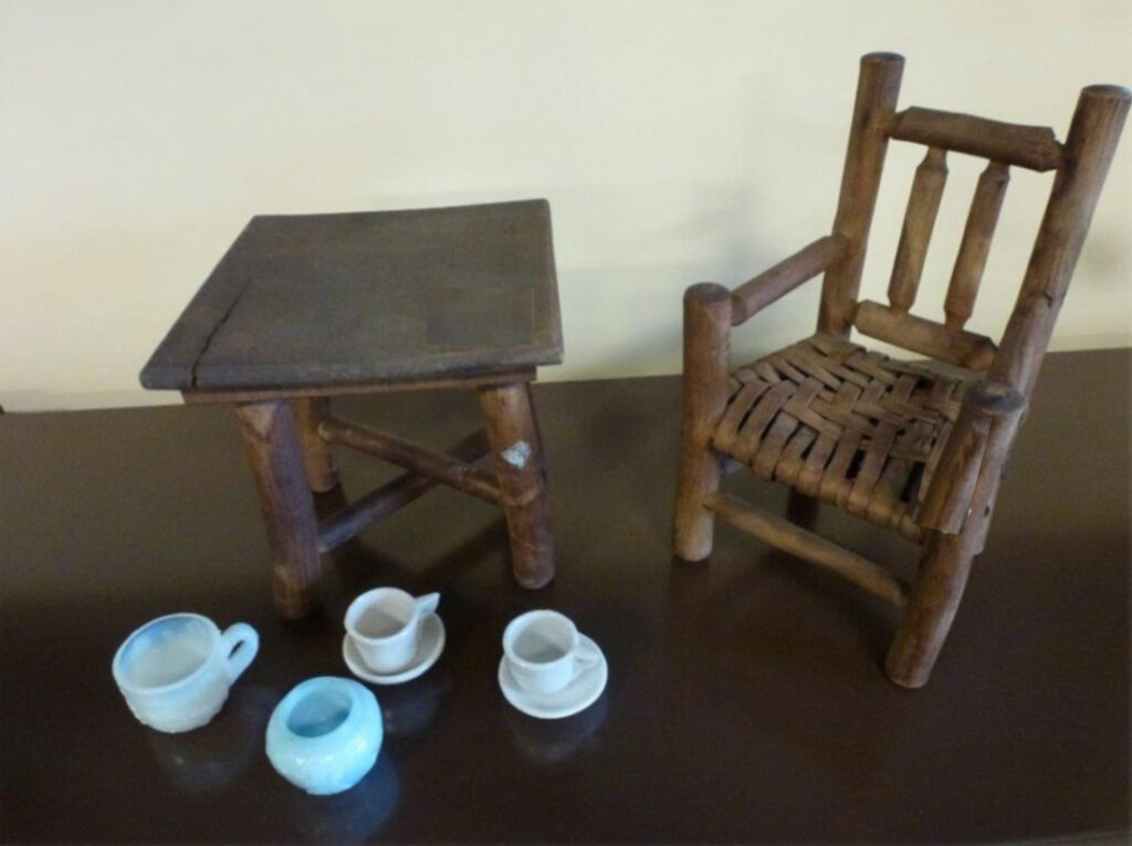 Table and chair with tea set used by children.